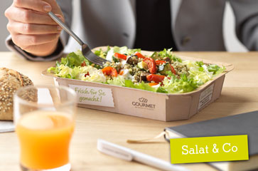 Person im Anzug isst den Salat von Salat & Co